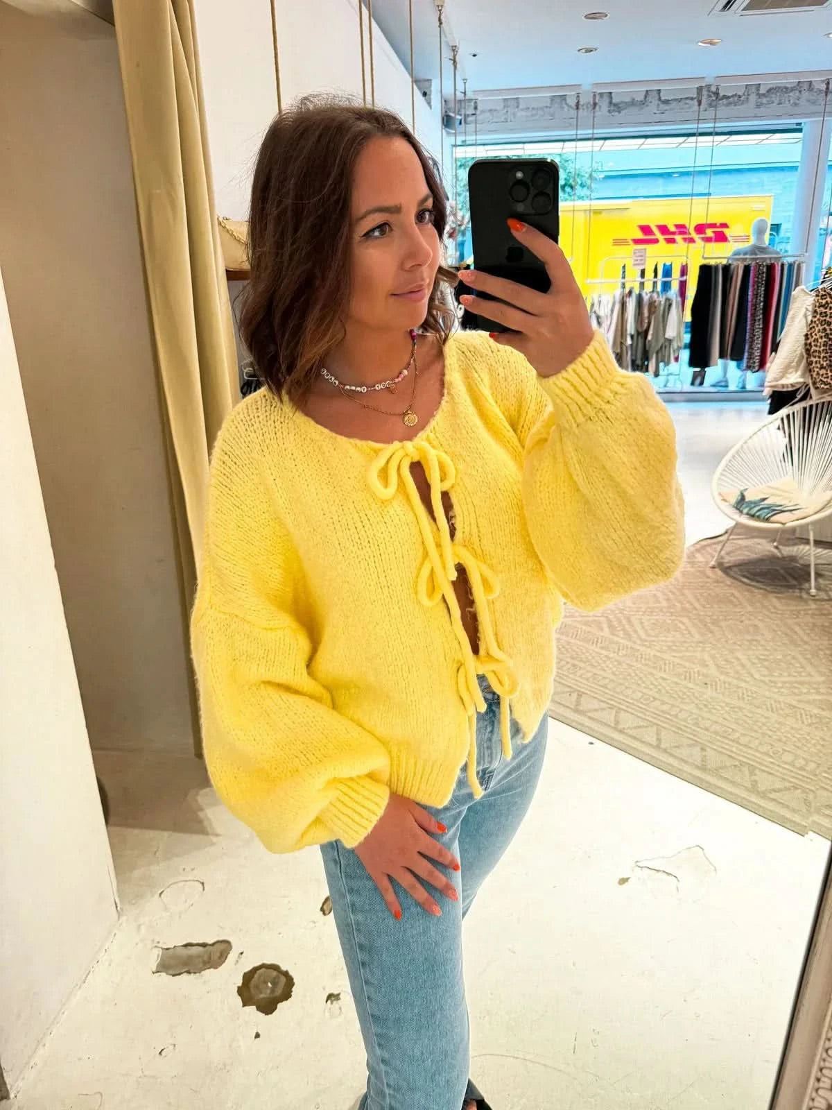 Bright yellow cardigan with bow neckline and voluminous sleeves