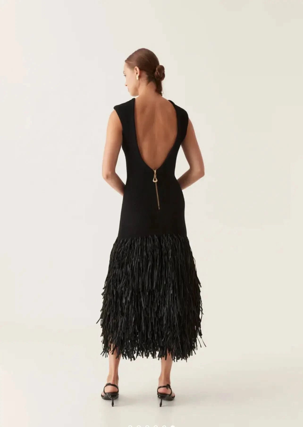 Back view of black midi dress with deep V-back and gold zip closure detail