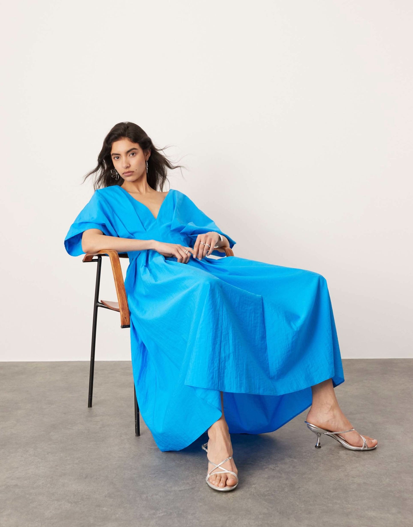 Blue midi wrap dress seated view showing relaxed fit and flowing hem for women