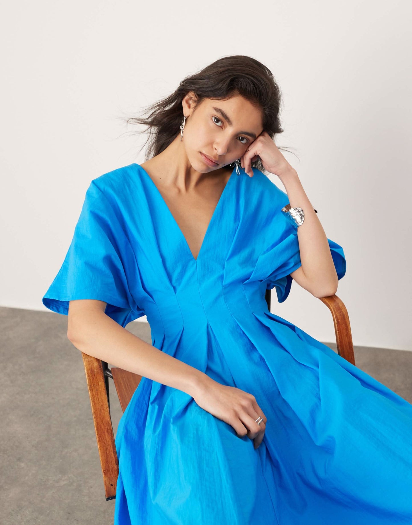 Close-up of blue wrap dress V-neckline and flutter sleeve detail for women