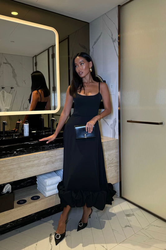 Black sleeveless midi dress with spaghetti straps and flowing skirt