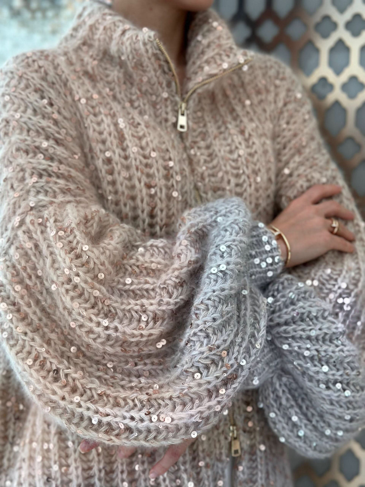 Close-up of chunky knit texture with scattered sequins on cardigan