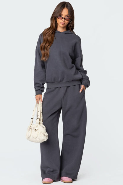 Women wearing charcoal gray lounge set with matching bow-embroidered hoodie and pants