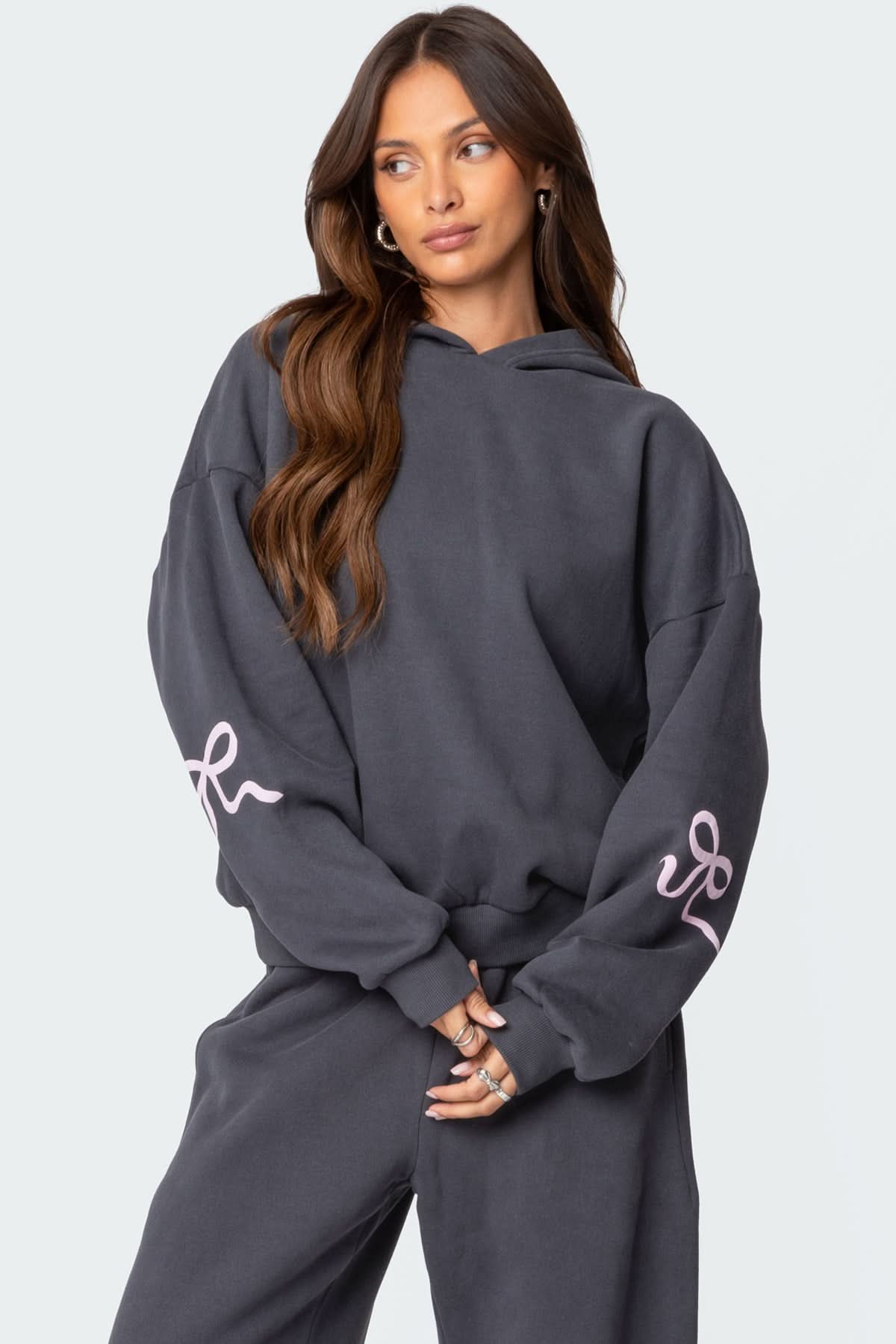 Charcoal gray pullover hoodie with pink bow sleeve graphic for women