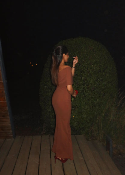 Side profile of caramel one-shoulder maxi dress with flowing hem