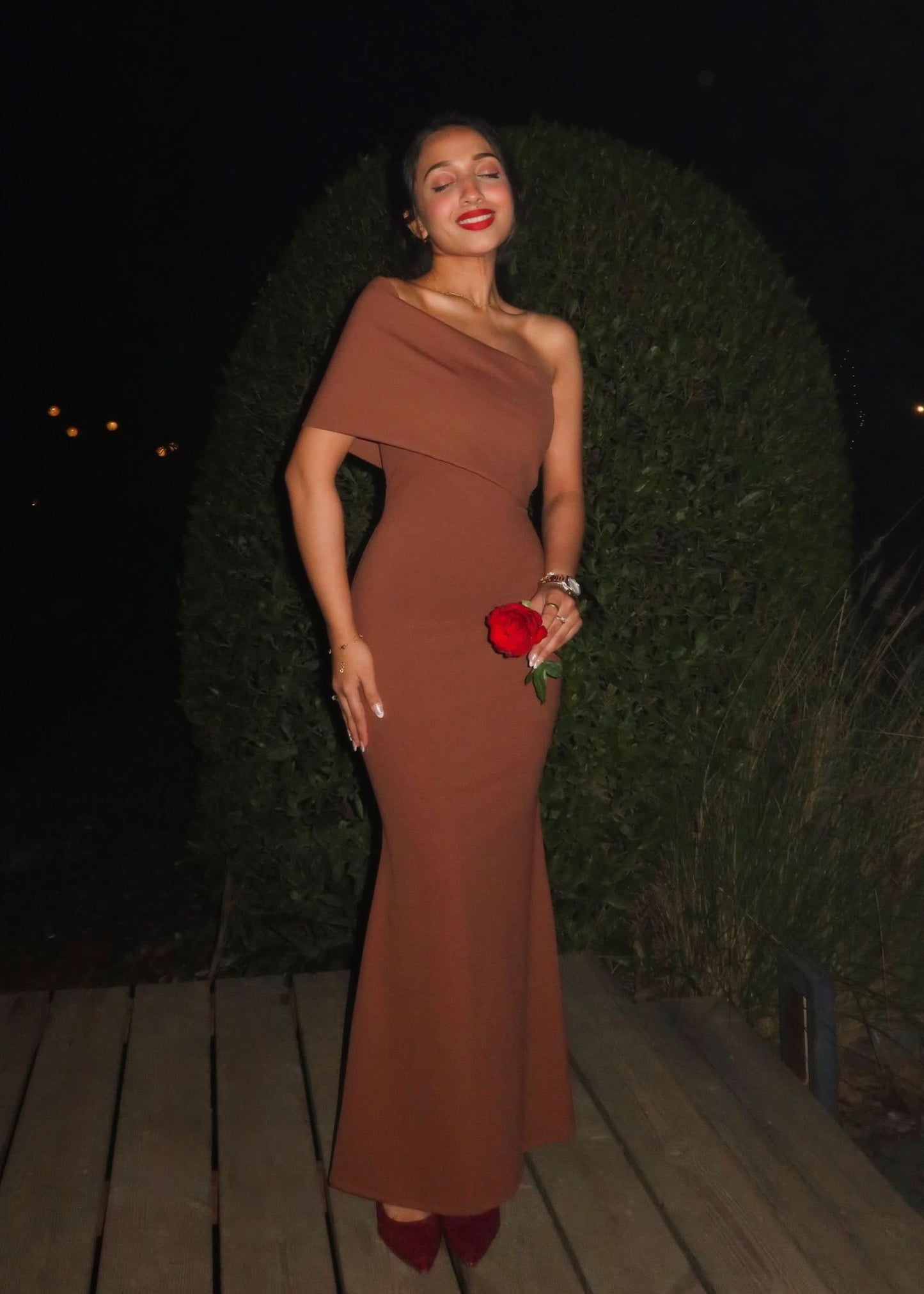 Caramel one-shoulder maxi dress with draped neckline and fitted silhouette