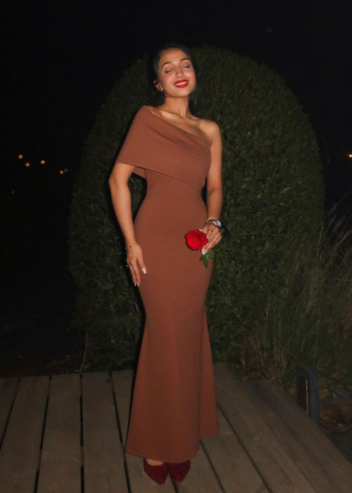 Caramel one-shoulder maxi dress with draped neckline and fitted silhouette