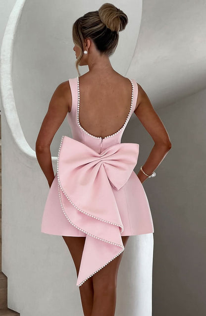 Black mini dress back view with pearl-beaded scoop back and asymmetrical bow