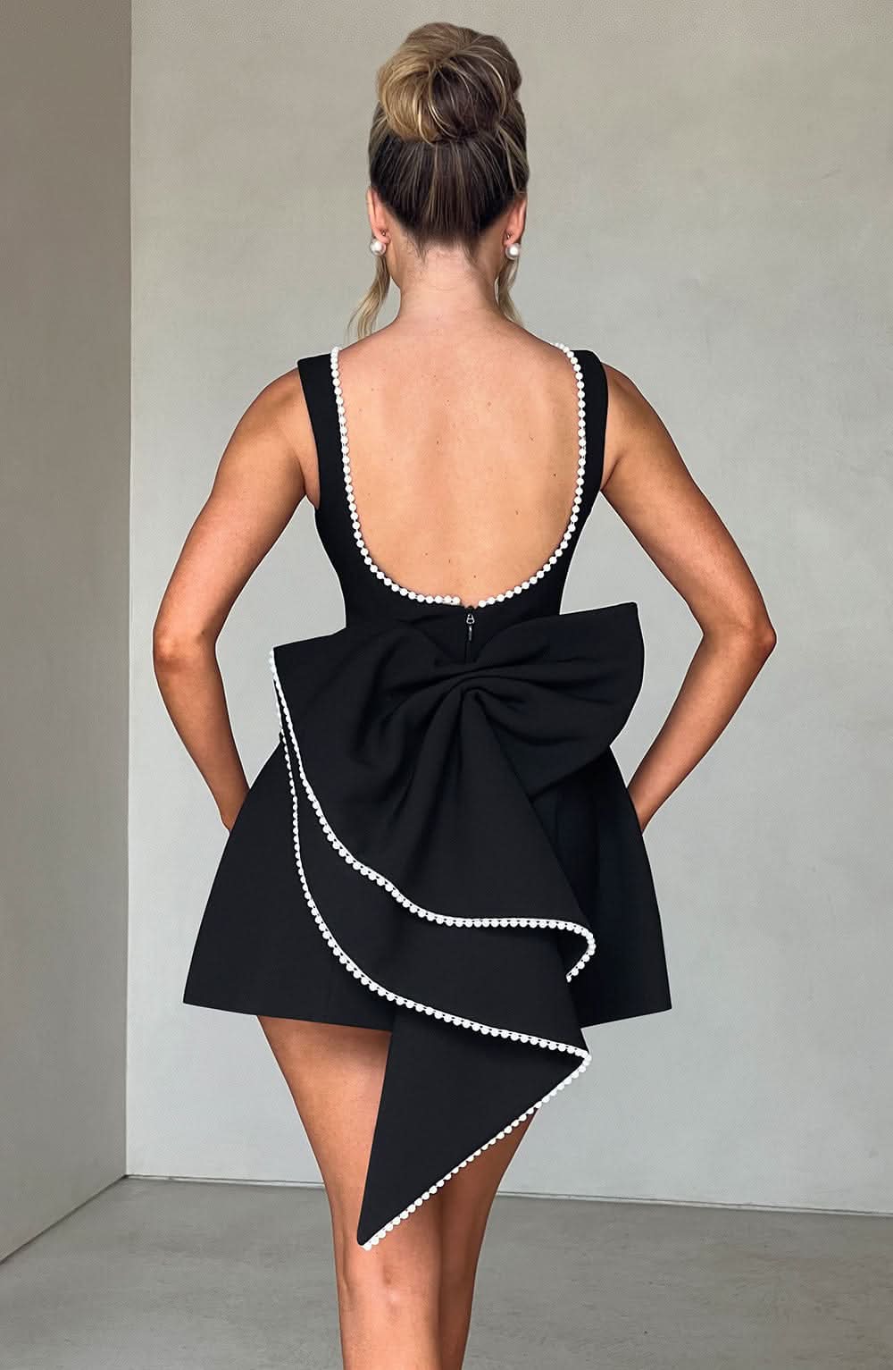 Black sleeveless mini dress with pearl neckline and side pockets