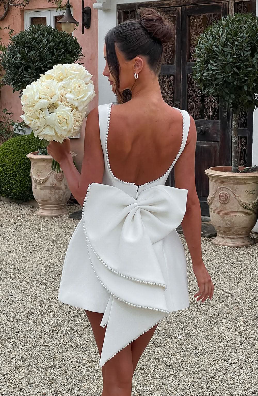 White mini dress with pearl-beaded back neckline and large bow detail