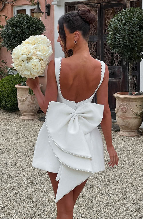 White mini dress with pearl-beaded back neckline and large bow detail