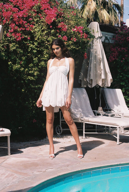 White halter mini dress with gathered bust and layered handkerchief hem detail