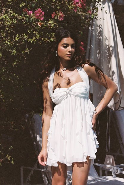 White halter mini dress with ruffled tiered skirt worn in garden setting