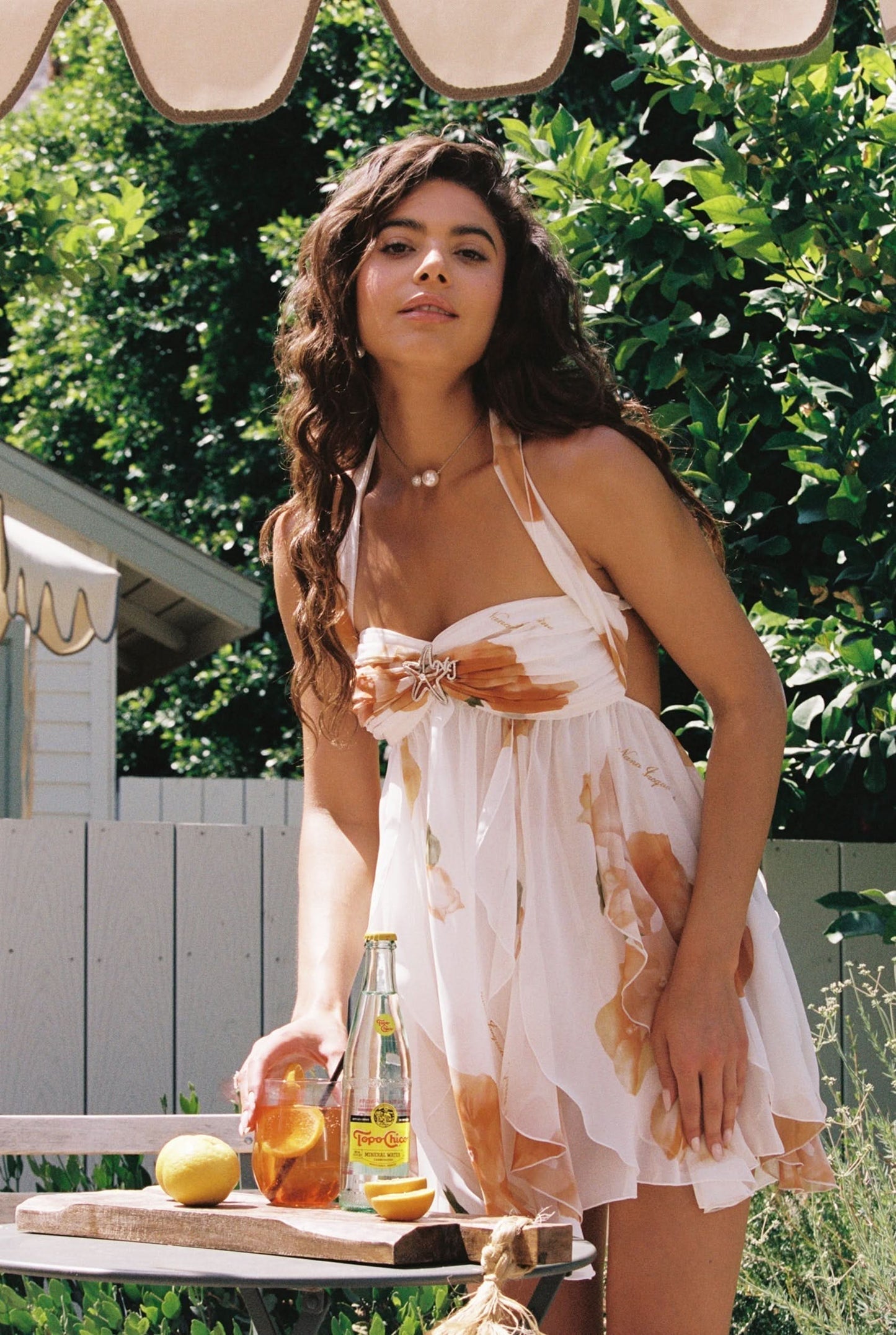 Cream halter mini dress with orange floral print and star buckle detail