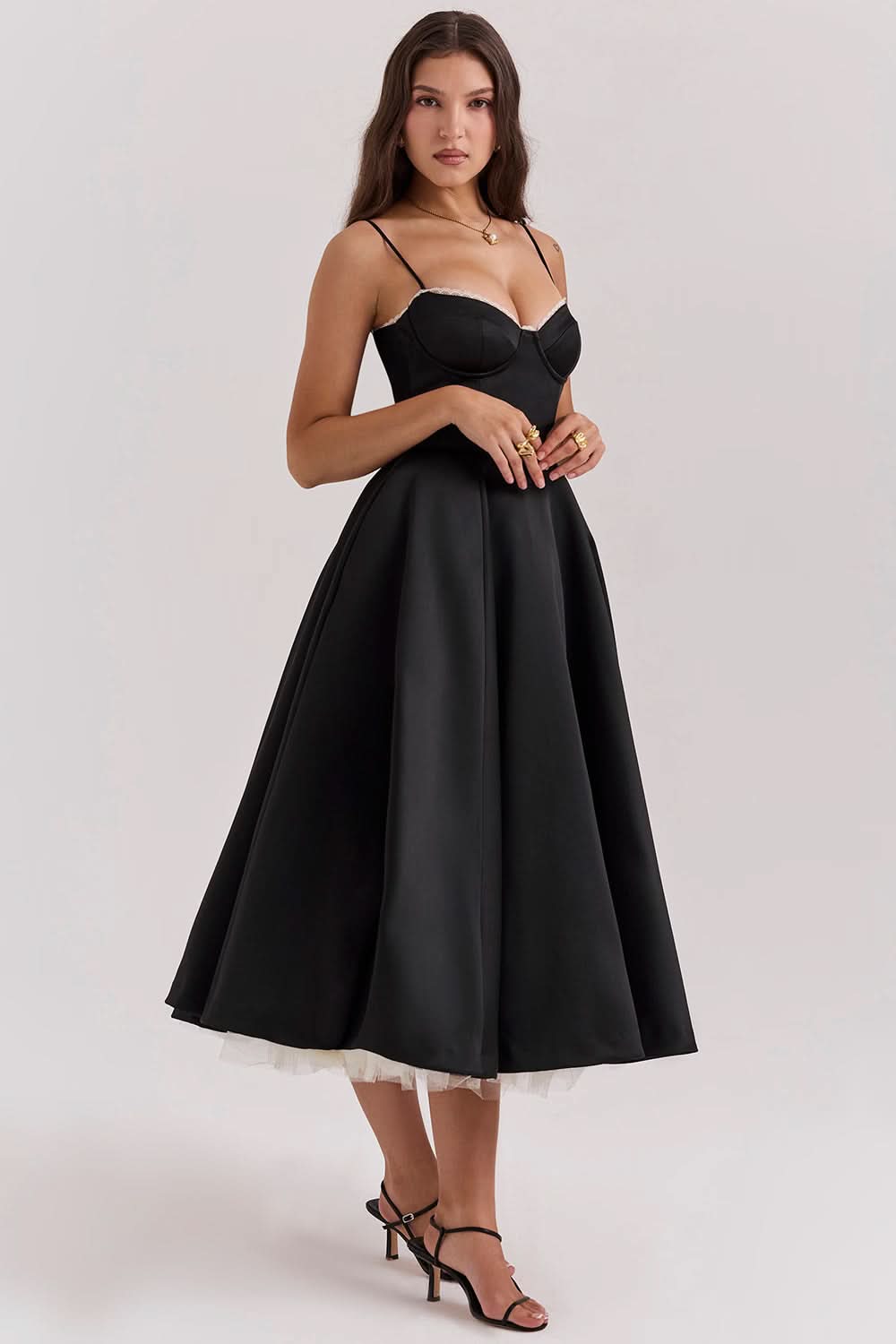Side profile of black midi dress with fitted bodice and voluminous skirt