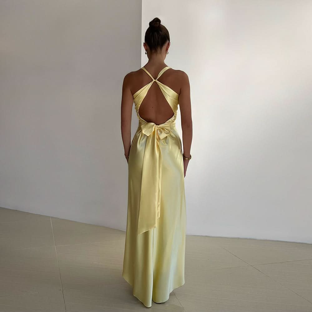 Back view of pale yellow maxi dress with open back and tied bow accent at waist
