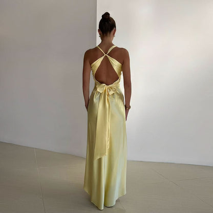 Back view of pale yellow maxi dress with open back and tied bow accent at waist