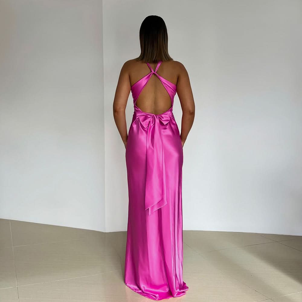 Magenta halter maxi dress with open back and flowing bow tie detail at lower back