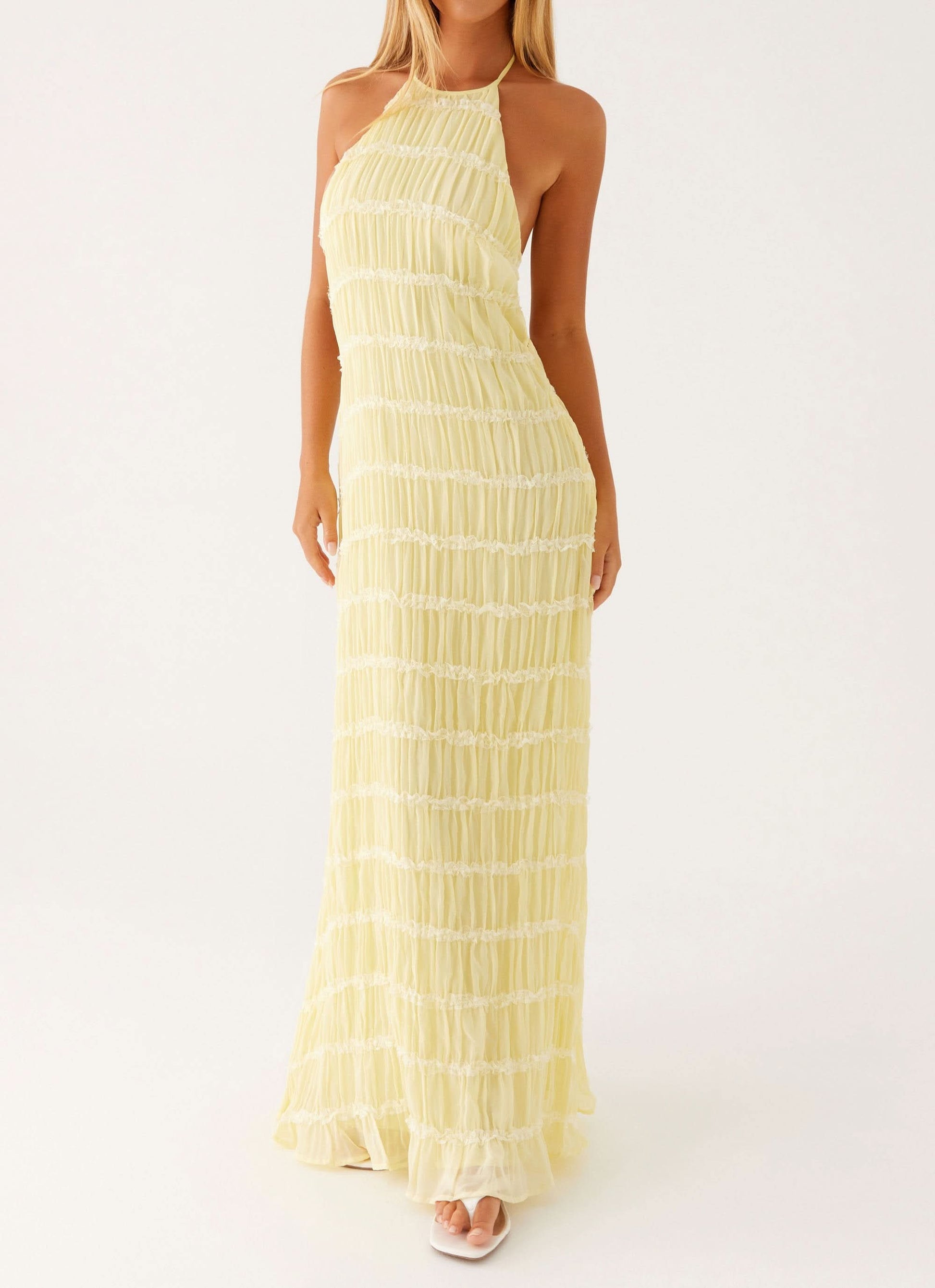 Front view of pale yellow halter maxi dress with tiered pleated skirt