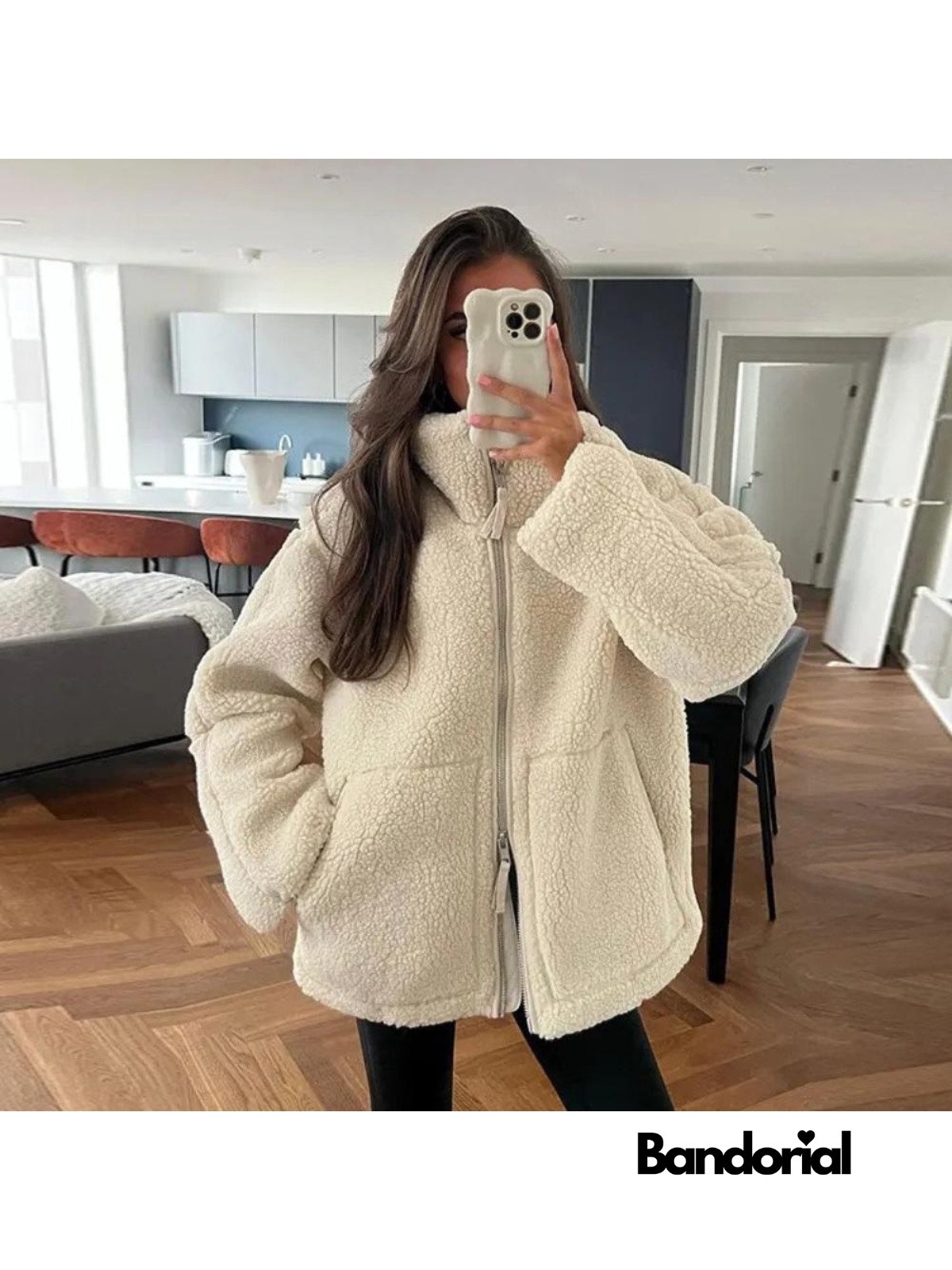 Woman wearing oversized cream teddy jacket with black leggings indoors