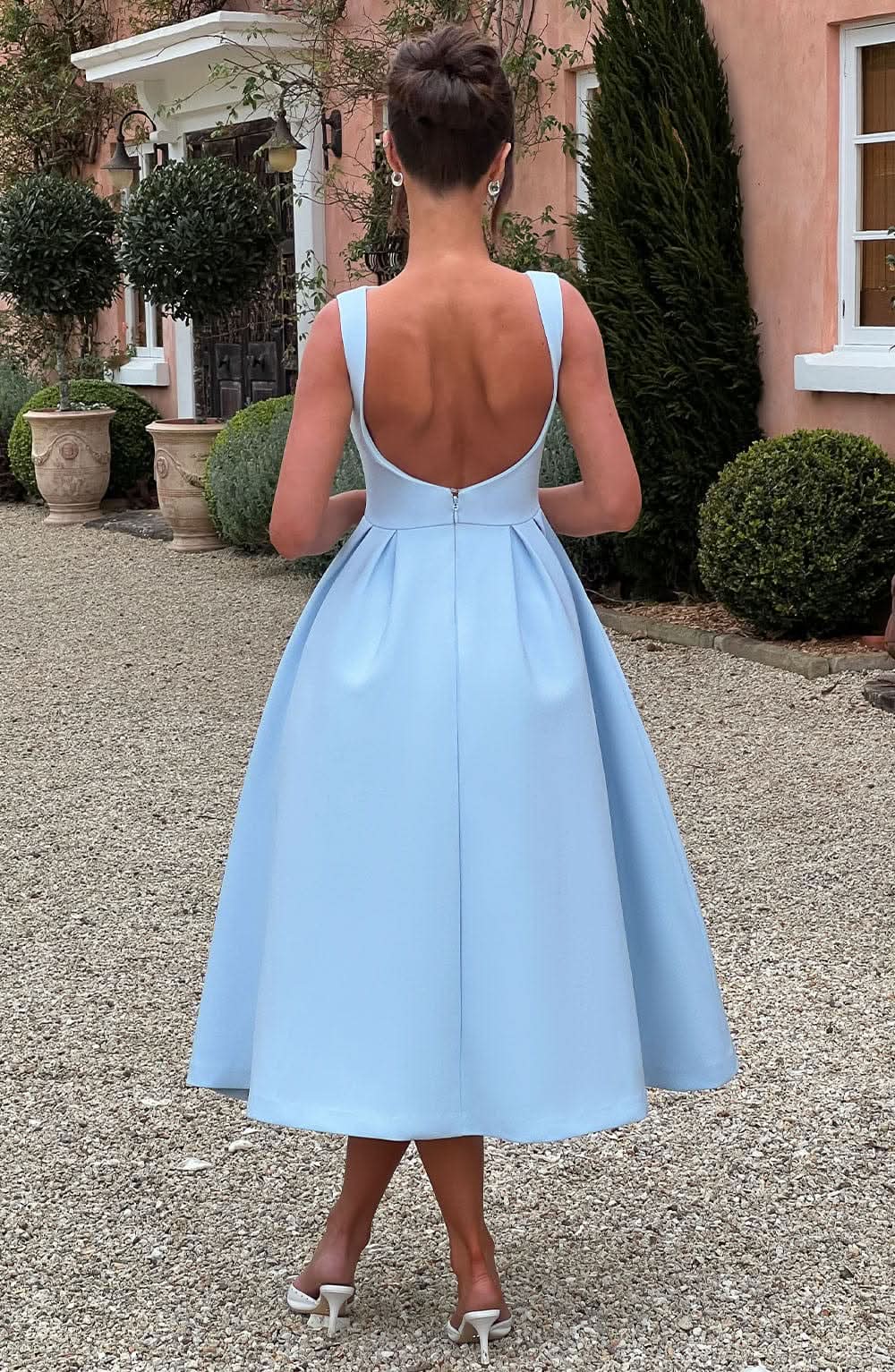 Back view of light blue midi dress showing open back design and zip closure