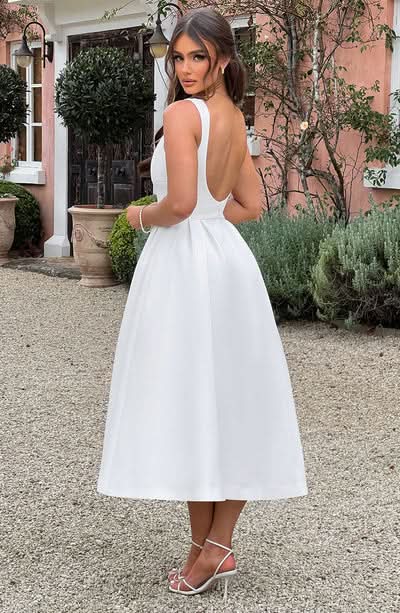 White sleeveless midi dress with open back and full skirt silhouette