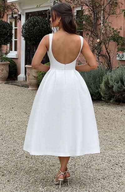 Back view of white midi dress with scoop back neckline and zip fastening