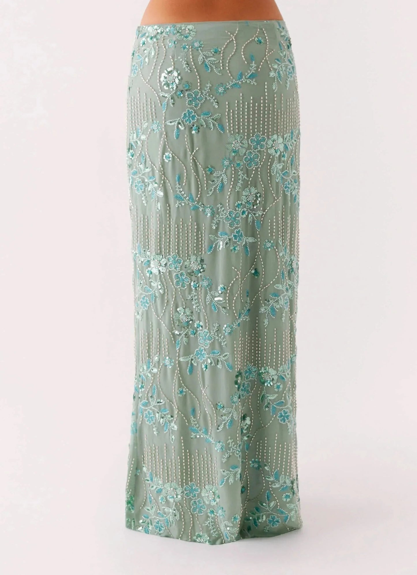 Sage green maxi skirt close-up showing intricate beaded floral pattern and fringe