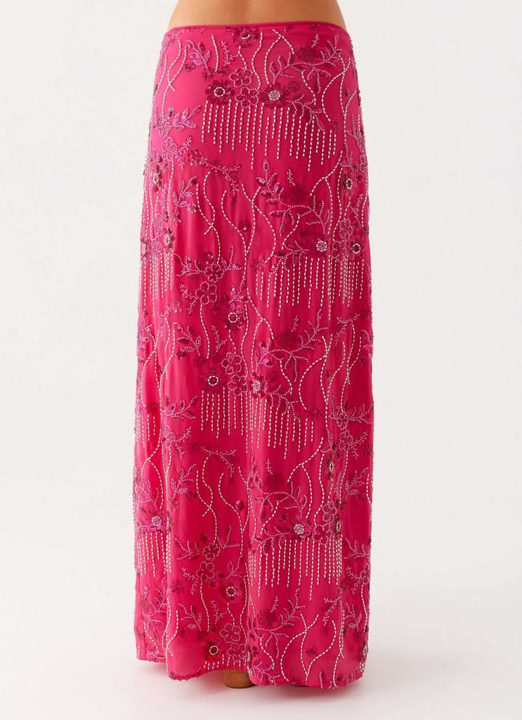 pink maxi skirt detail showing ornate beaded flowers and dangling bead accents