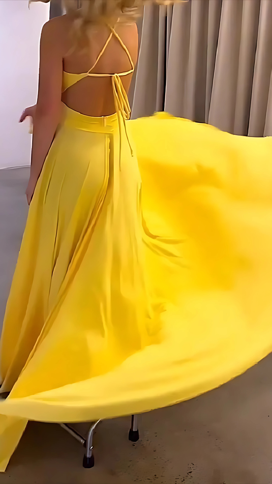 Back view of yellow maxi dress showing tie-back detail and floor-length train