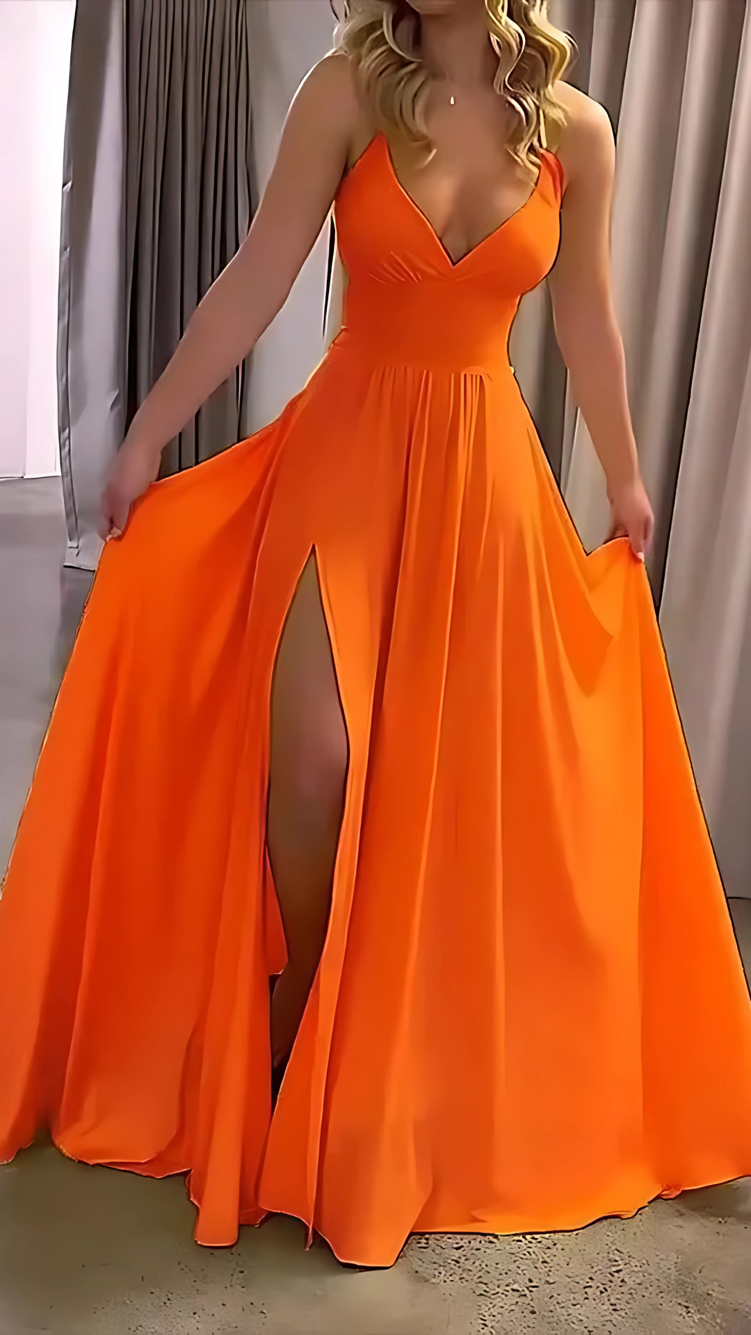 Bright orange halter maxi dress with fitted bodice and flowing floor-length skirt
