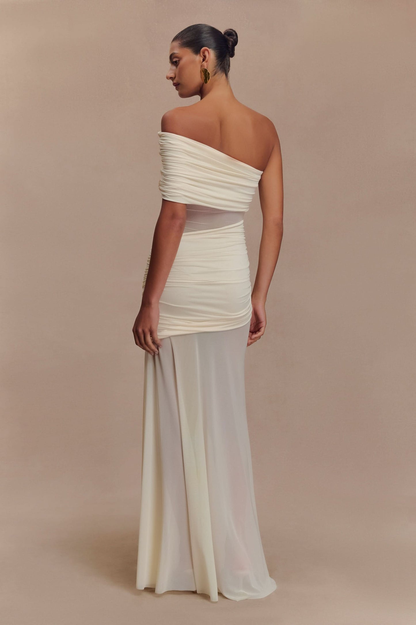 Back view of cream off-shoulder maxi dress with ruched fabric details