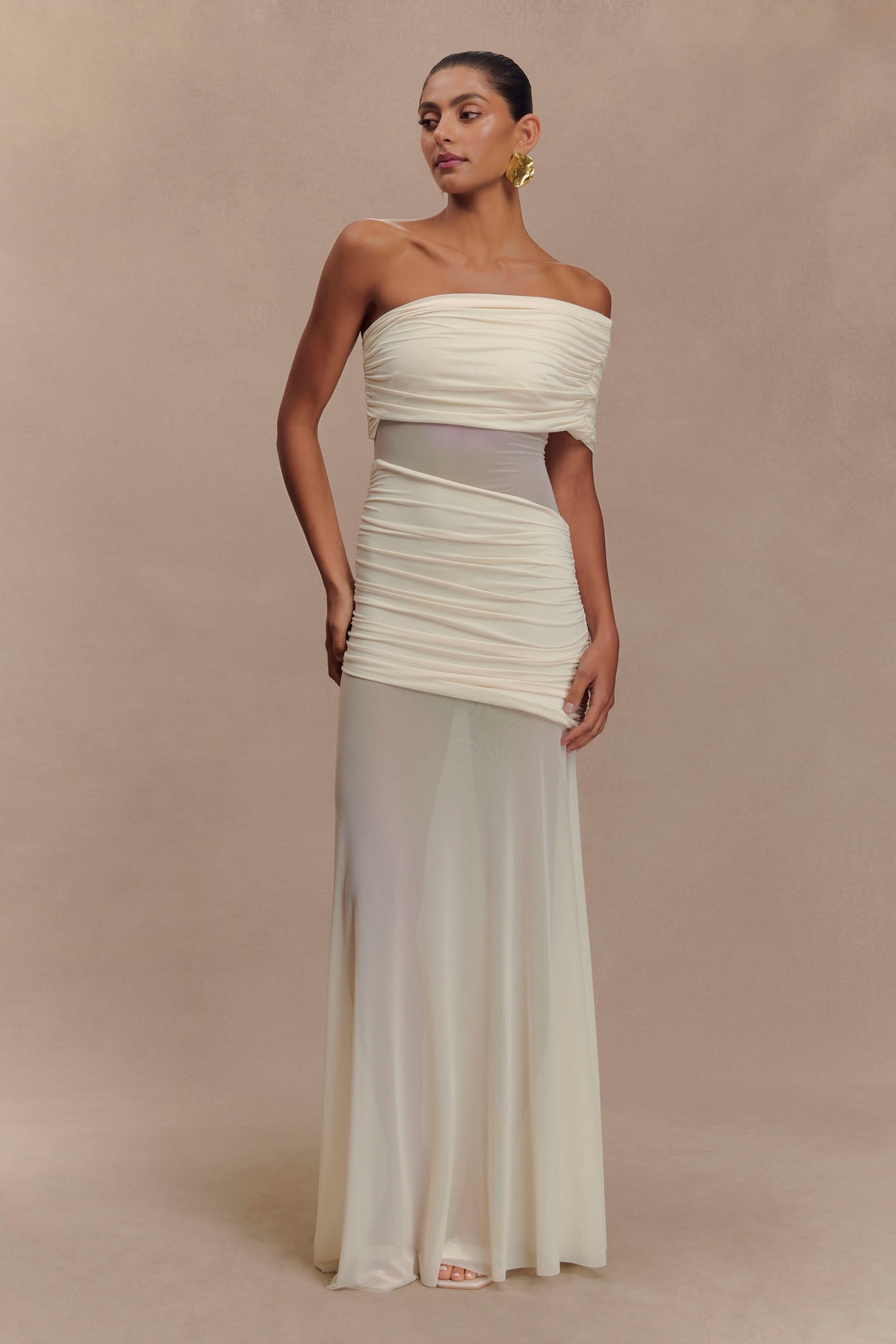 Cream off-shoulder evening gown with ruched bodice and flowing maxi skirt