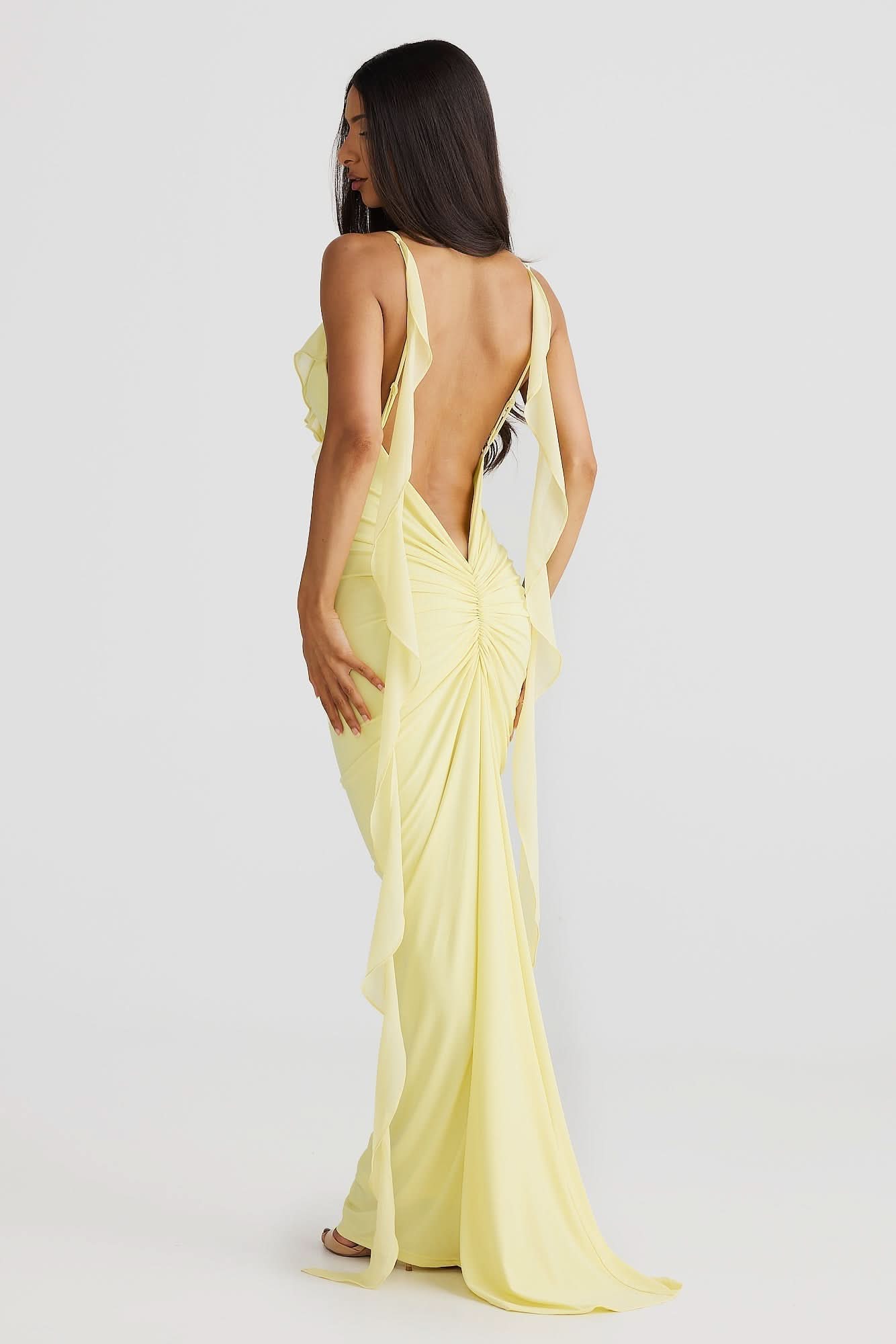 Back view of yellow wrap maxi dress with open back and cascading chiffon side panels