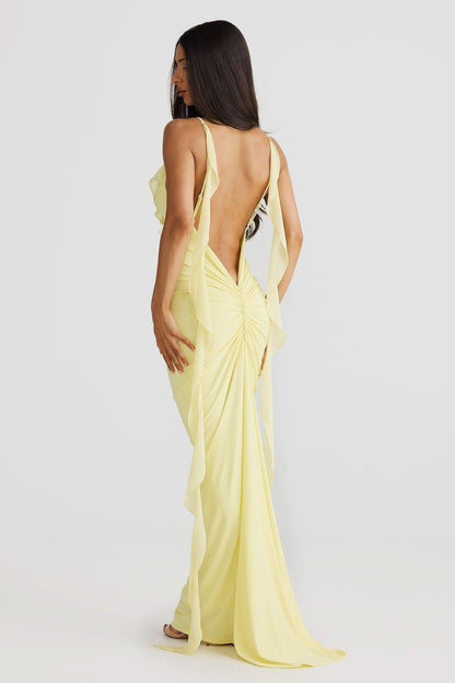 Back view of yellow wrap maxi dress with open back and cascading chiffon side panels