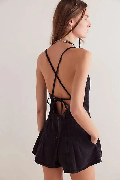 Back view of black denim romper with lace-up tie detail and open back design