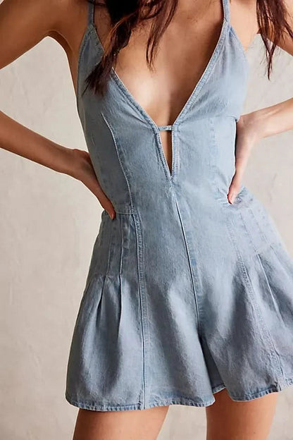 Light blue denim romper with V-neckline and pleated skirt detail, front view