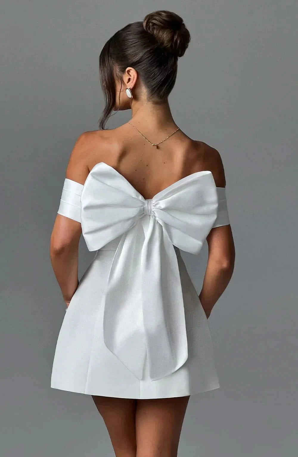 White mini dress with oversized back bow and off-shoulder neckline