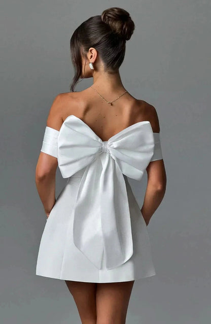 White mini dress with oversized back bow and off-shoulder neckline