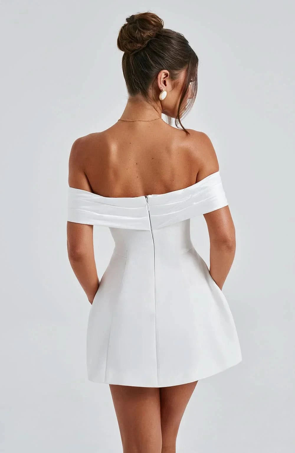 Back view of white off-shoulder mini dress with draped bow detail