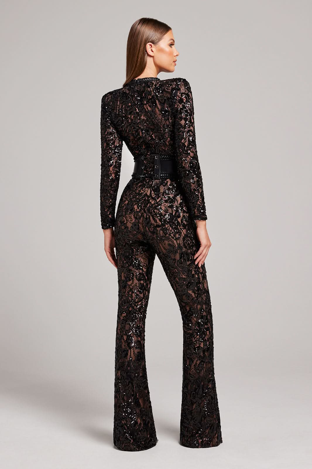 Back view of black lace jumpsuit with studded belt