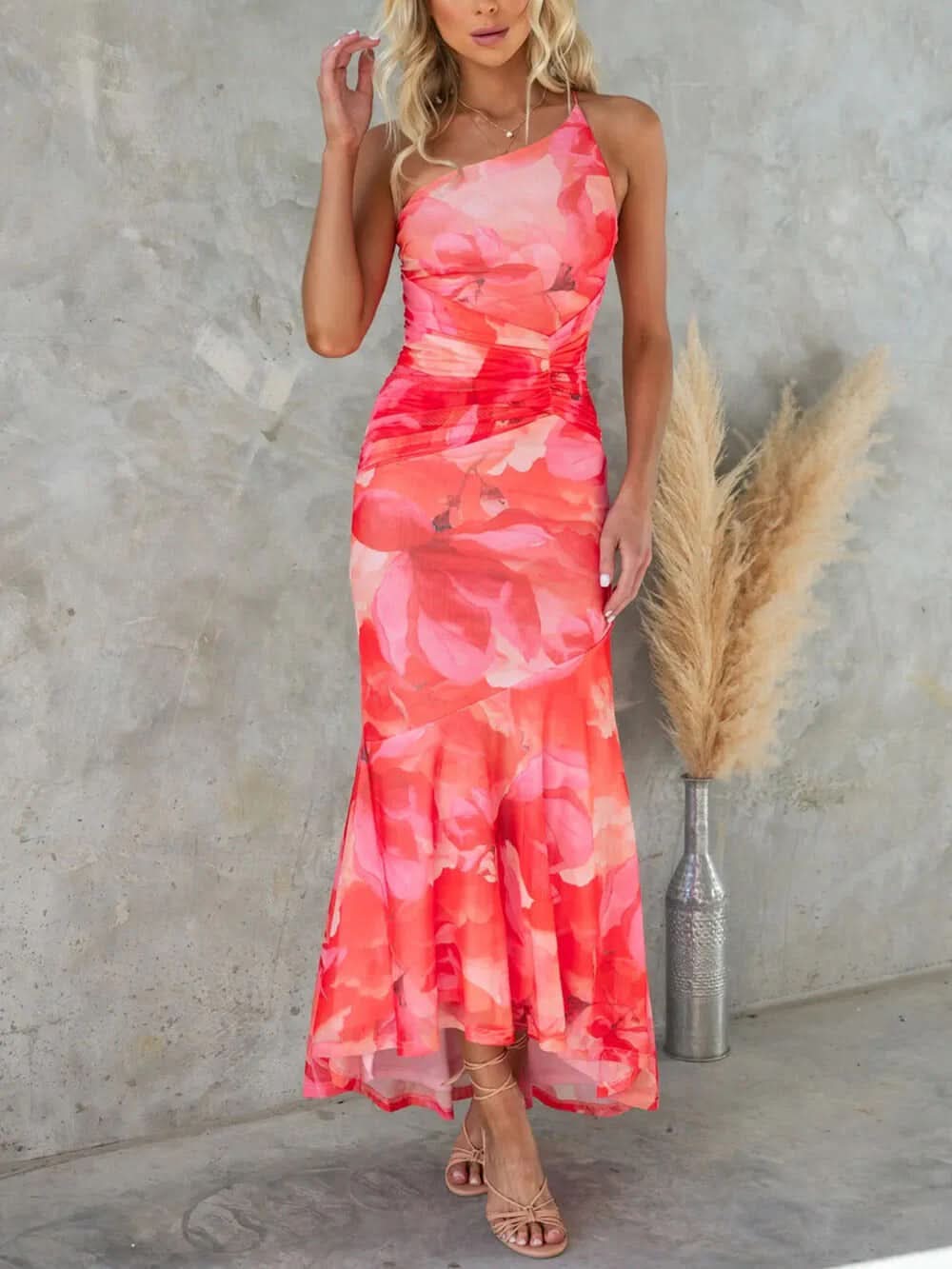 Front view of coral pink floral maxi dress with asymmetrical hem
