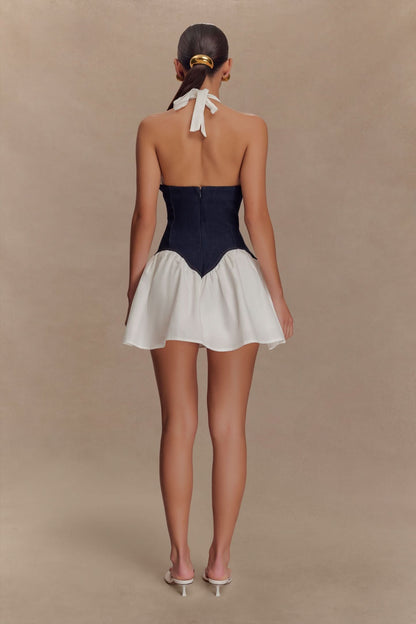 Back view of halter mini dress showing white tie closure and navy corset with flared cream skirt
