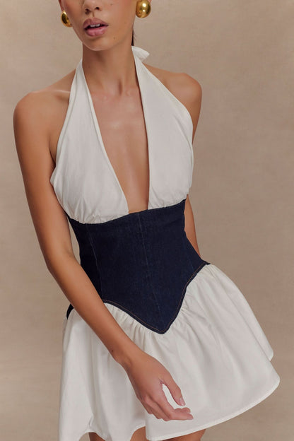 Close-up of halter mini dress neckline with white fabric and navy denim corset detail