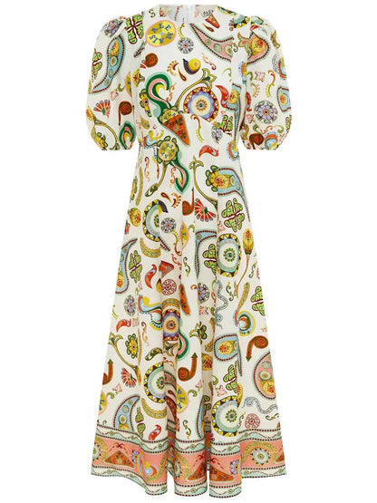 Full-length flat lay of cream midi dress with vibrant paisley print and decorative hem