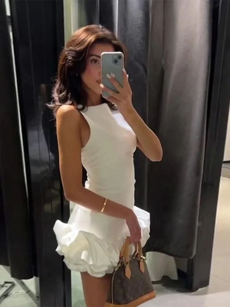 White sleeveless mini dress with bubble hem worn with brown shoulder bag