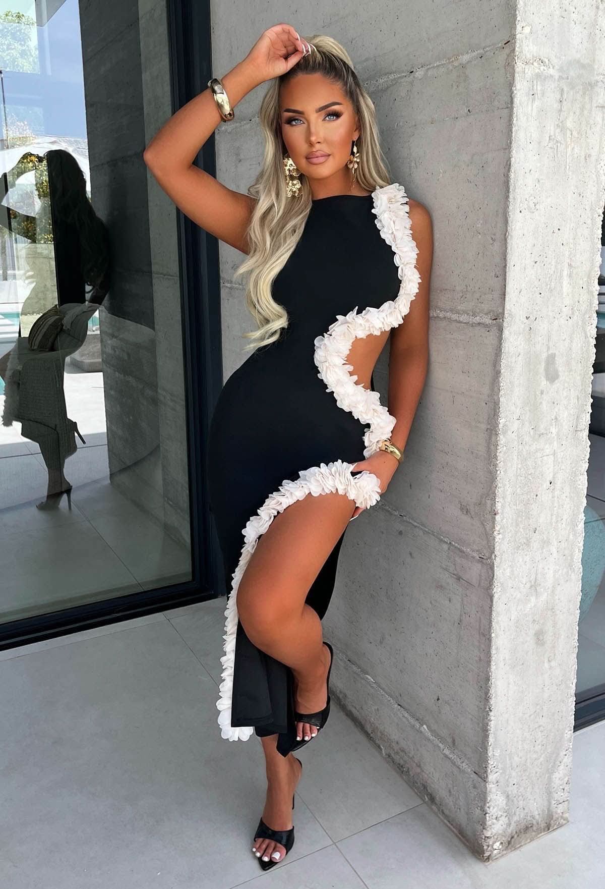 Black sleeveless maxi dress with white ruffled cutout trim diagonal design