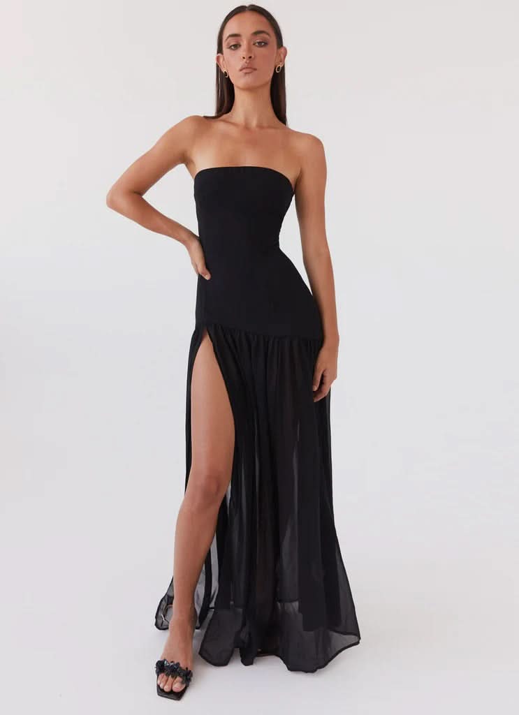 Black strapless maxi dress with ruched drop waist and flowing skirt, back view