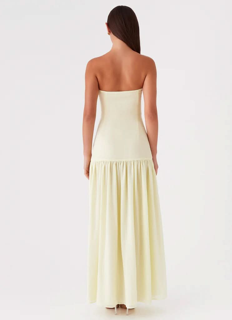 Back view of cream strapless maxi dress showing fitted bodice and flowing skirt