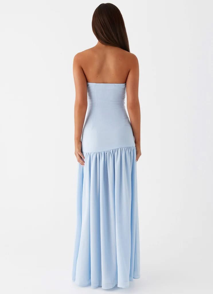 Side profile of light blue strapless maxi dress showing high leg slit